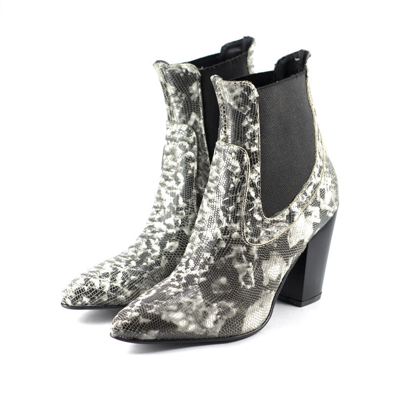 A closeup of leather, snake patterned high-heeled female shoes isolated on a white background
